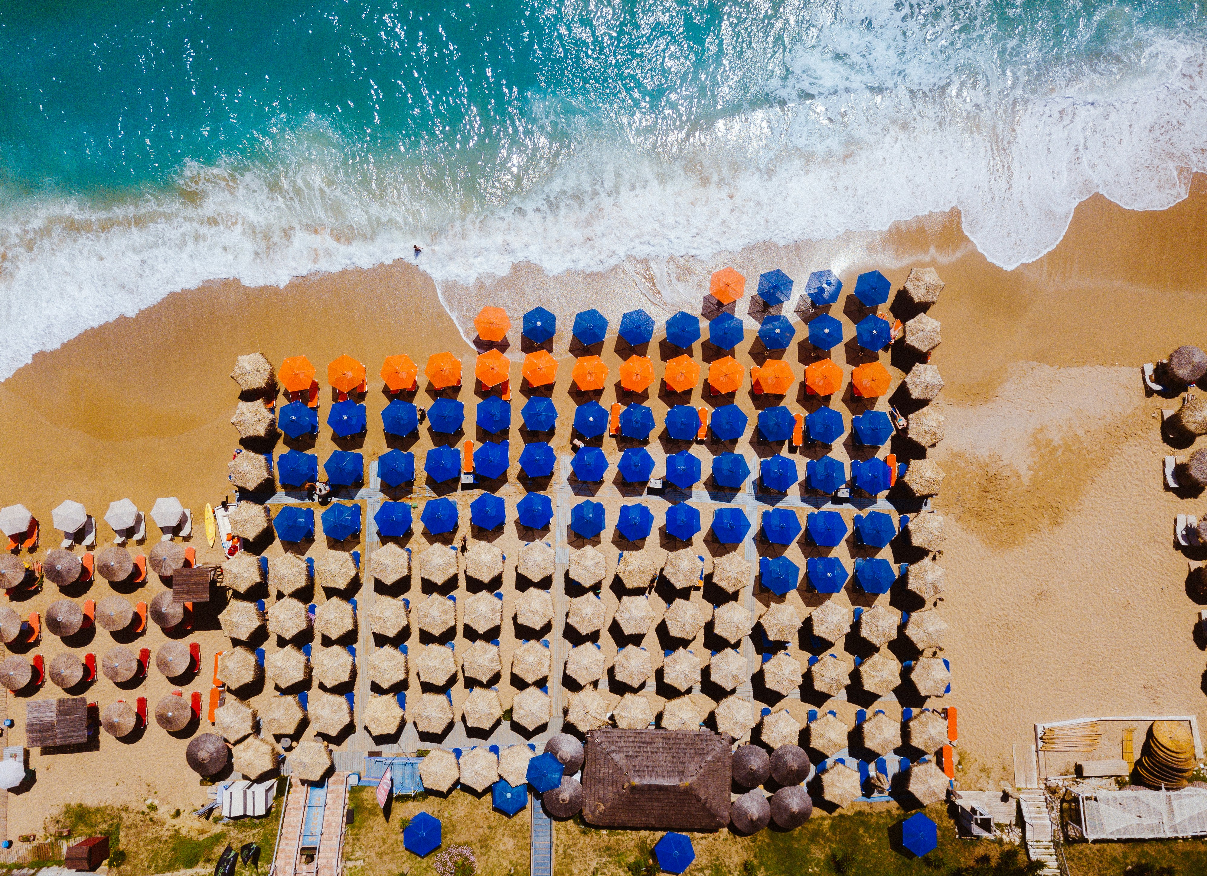 assorted-color umbrellas near seashore in top view photography